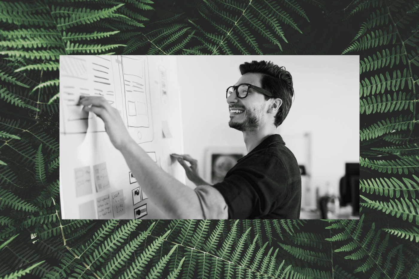Web designer sketching website wireframes on a whiteboard, illustrating the planning process behind nonprofit web design.
