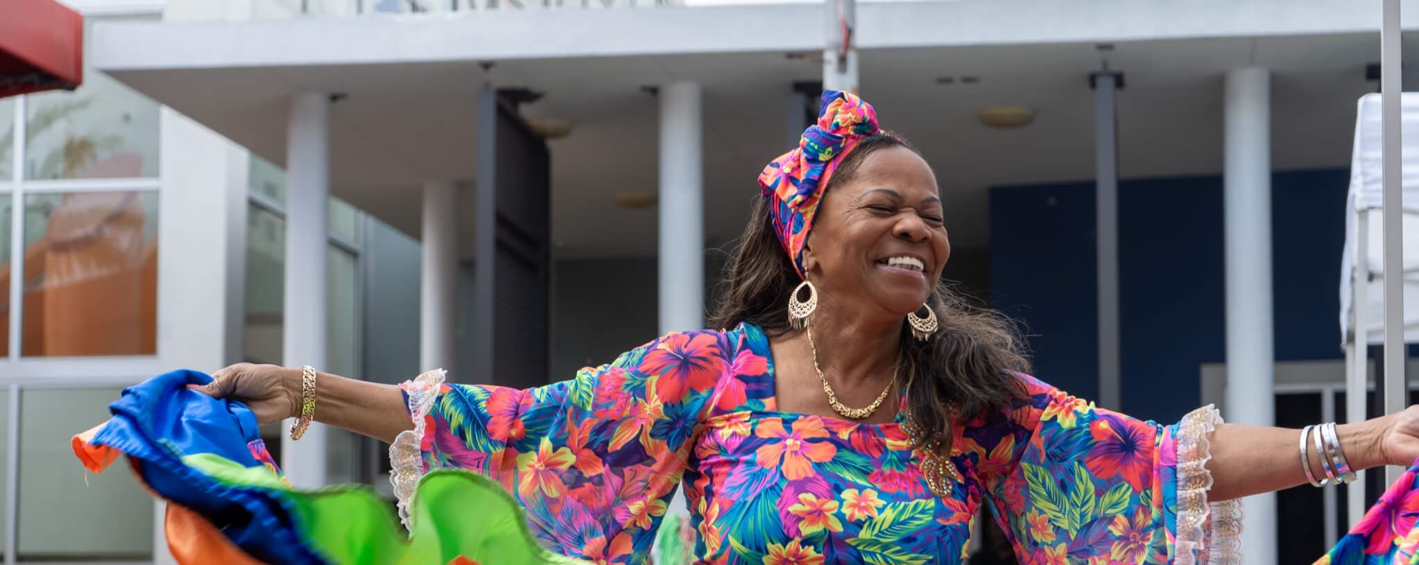 A Black woman dances in a printed dress