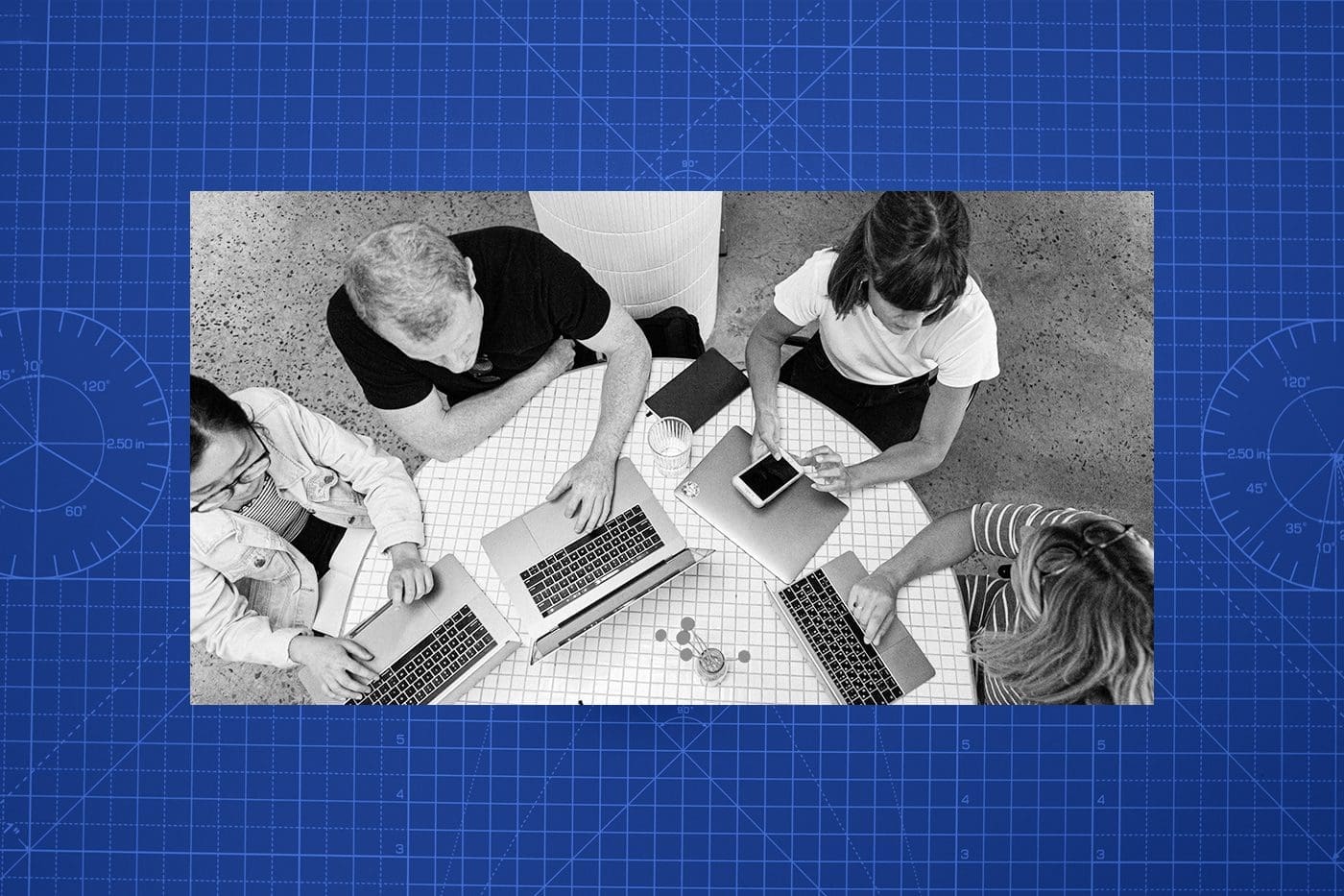 Group of nonprofit employees sitting around a table on their laptops