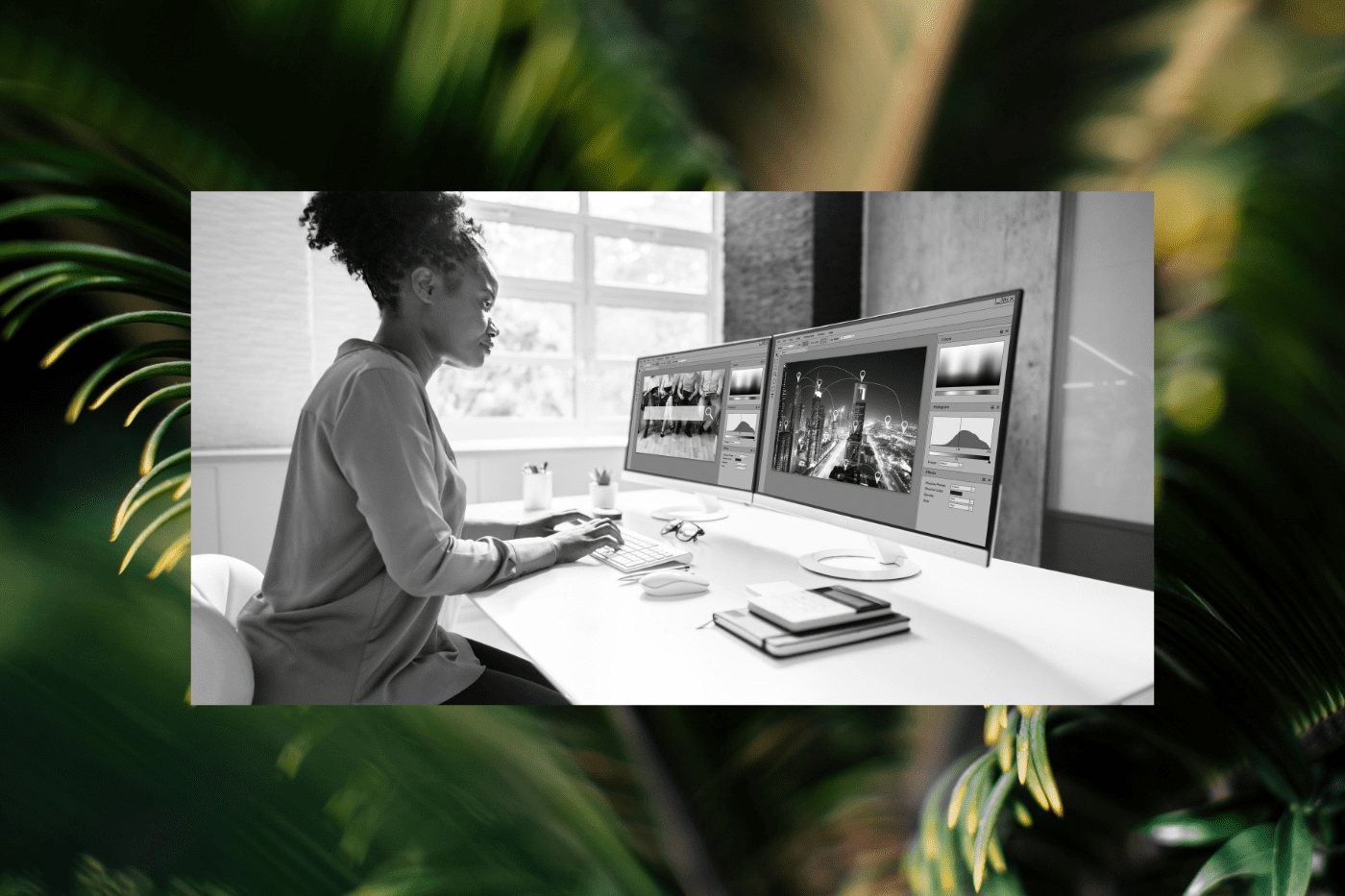 Person reviewing website redesign assets and layouts across dual monitors while planning content, SEO, and site performance strategy for a complete website redesign checklist.