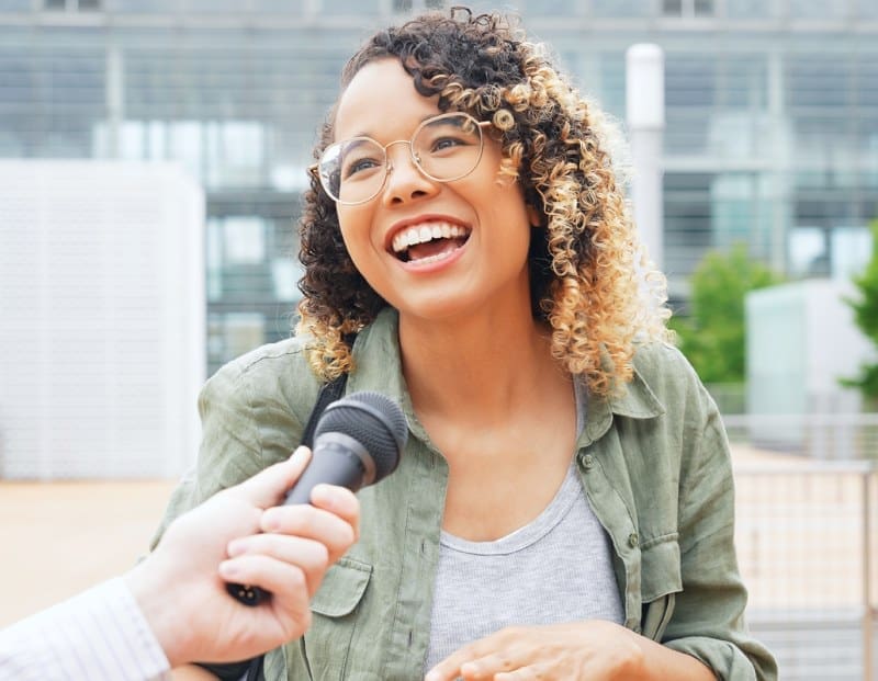 Smiling woman being interviewed for a story.
